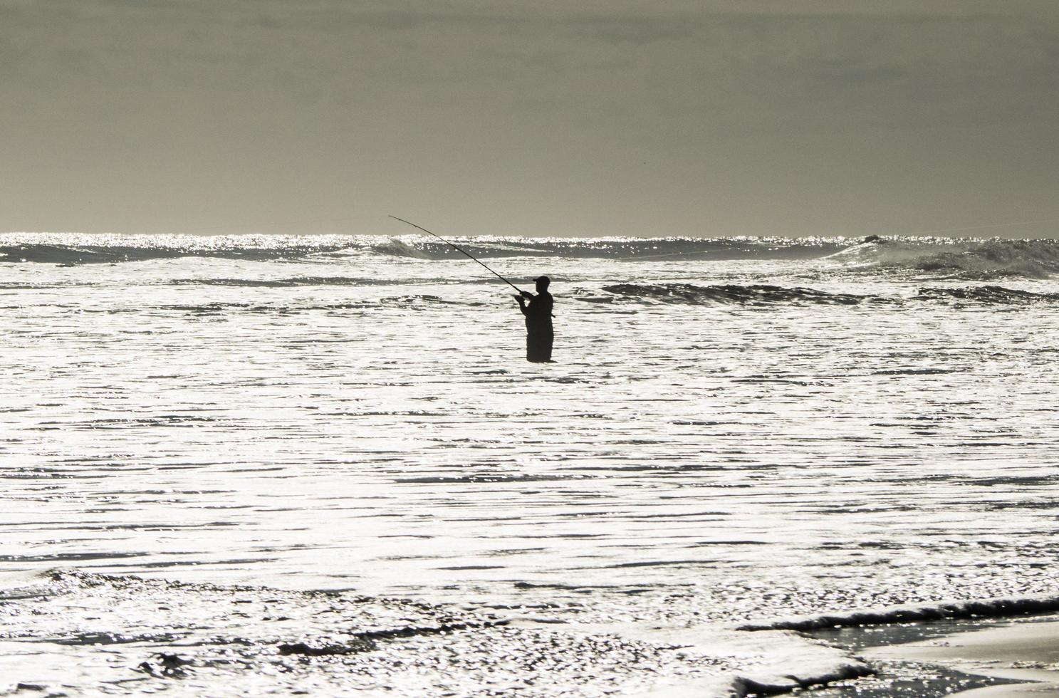 A fisherman in the ocean photo