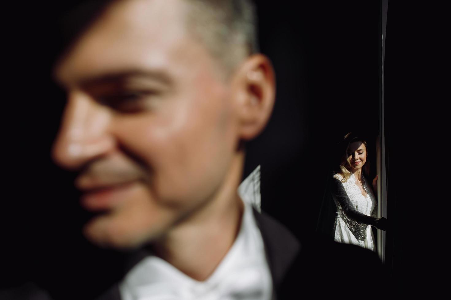 Handsome groom standing before his bride photo