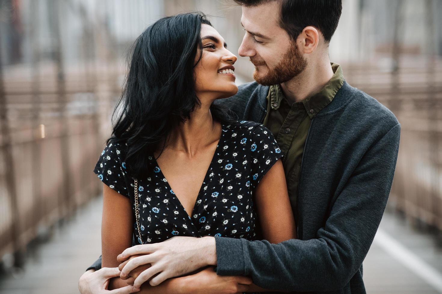 atractiva pareja se abraza en el puente de la ciudad foto