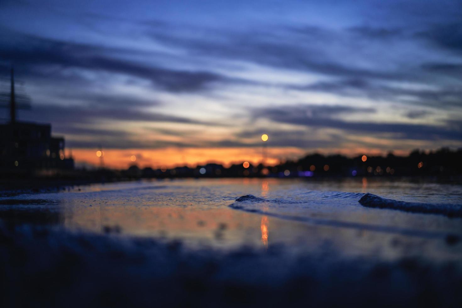 Low angle close-up of waves on the seashore during nighttime photo