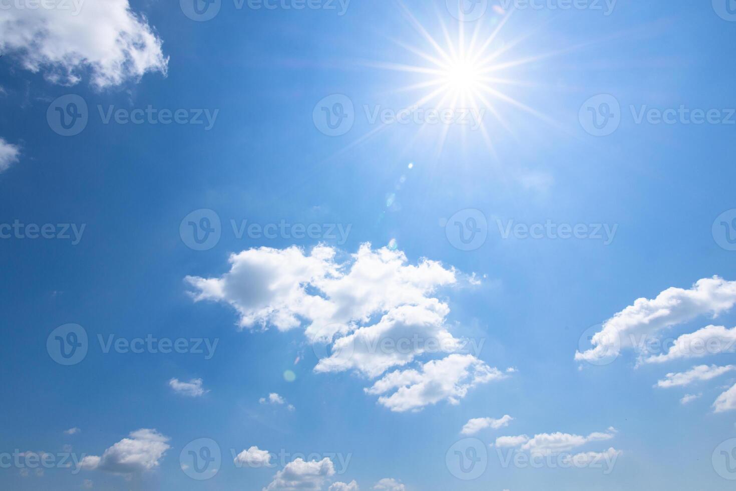 A blue sky with clouds and a bright sun photo