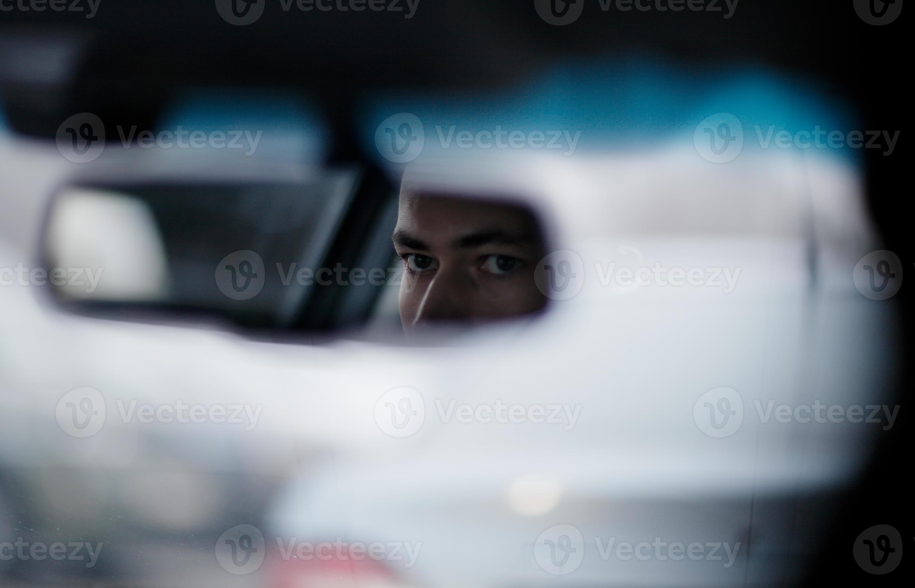 Man looking in the rear view mirror while driving 1423925 Stock Photo