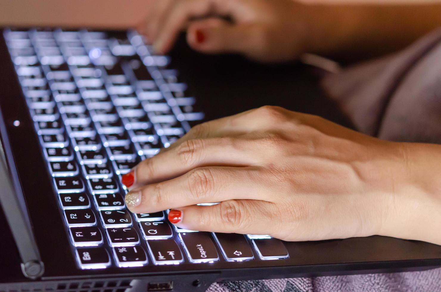 Close-up of woman typing on laptop photo