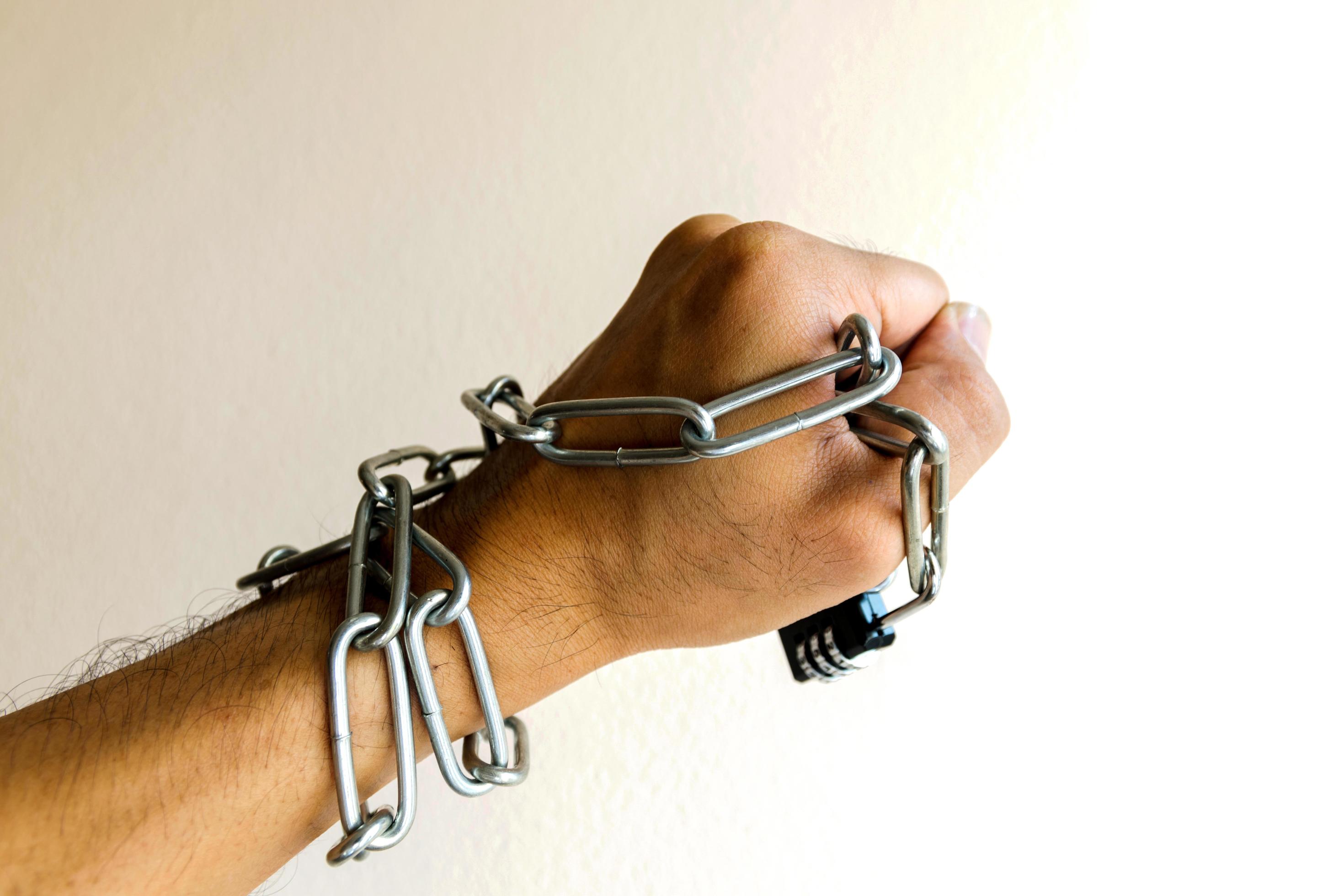 Person's hand locked by a chain 1430118 Stock Photo at Vecteezy