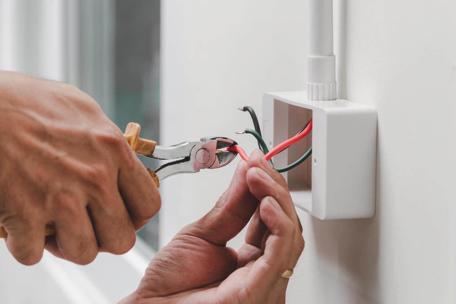 Electrician installs electrical outlet photo