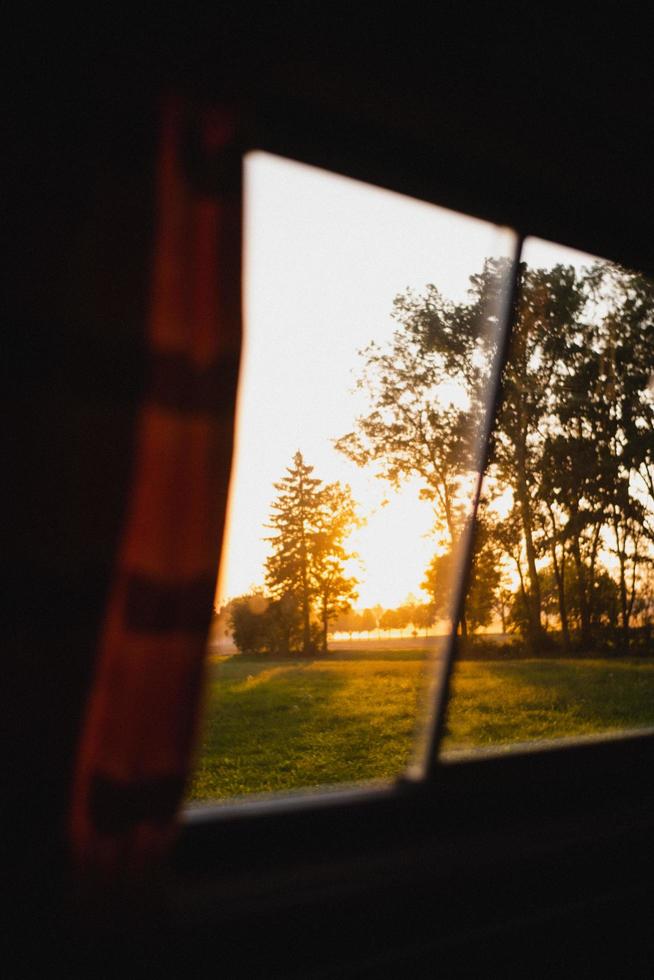 View of rising sun from window photo