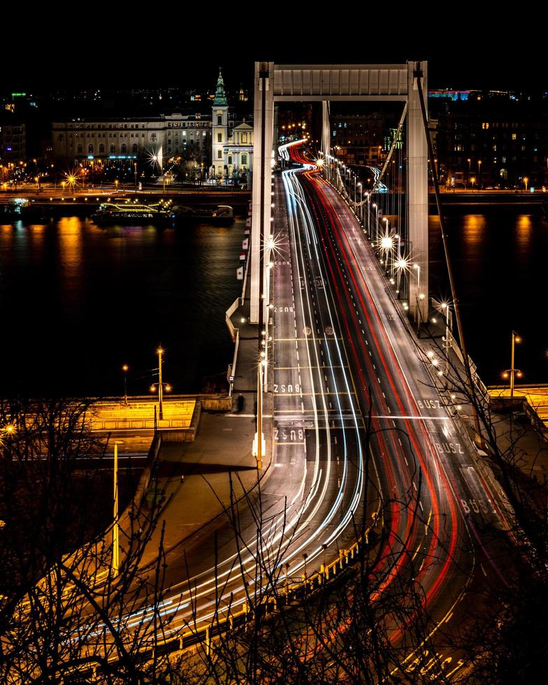 budapest, hungría, 2020 - larga exposición de las luces del coche en el puente elisabeth por la noche foto