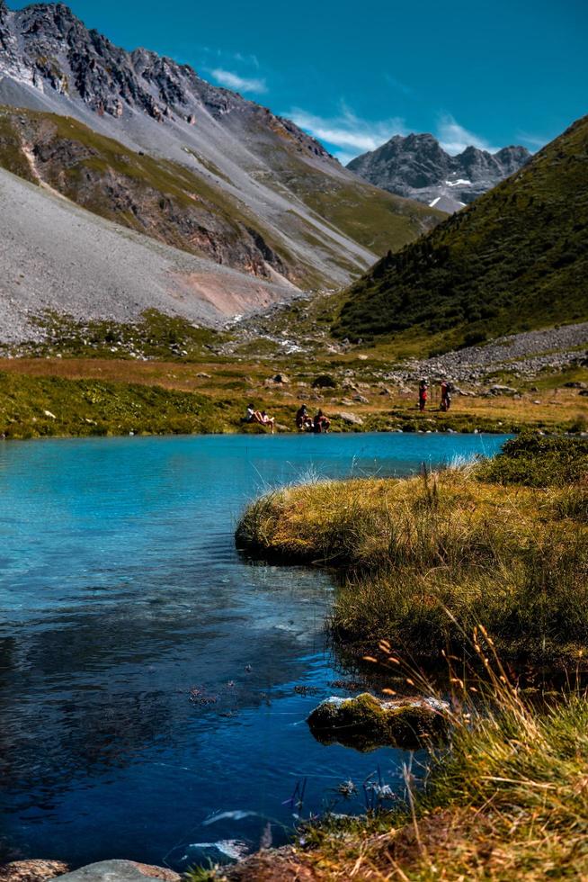 Beaufort, France, 20200 - Hikers near Fairy Lake in the French Alps photo