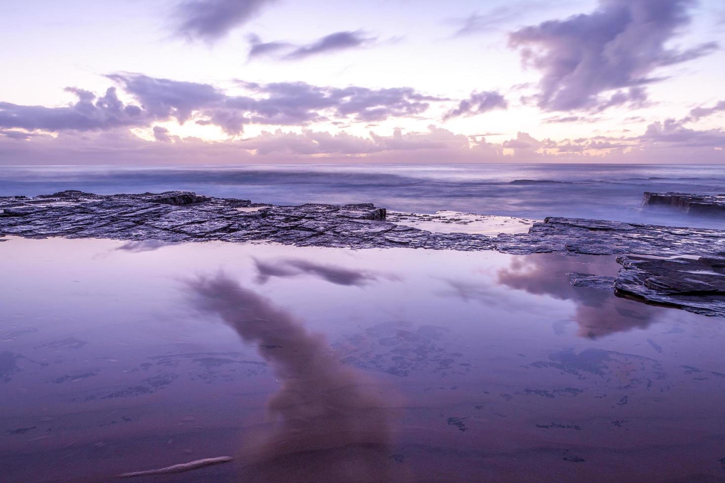 larga exposición de una puesta de sol púrpura y rosa foto