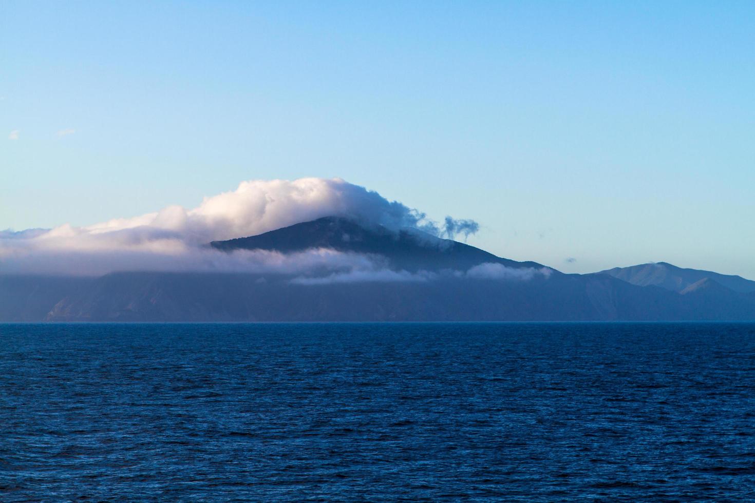 montaña cubierta de niebla cerca del océano foto