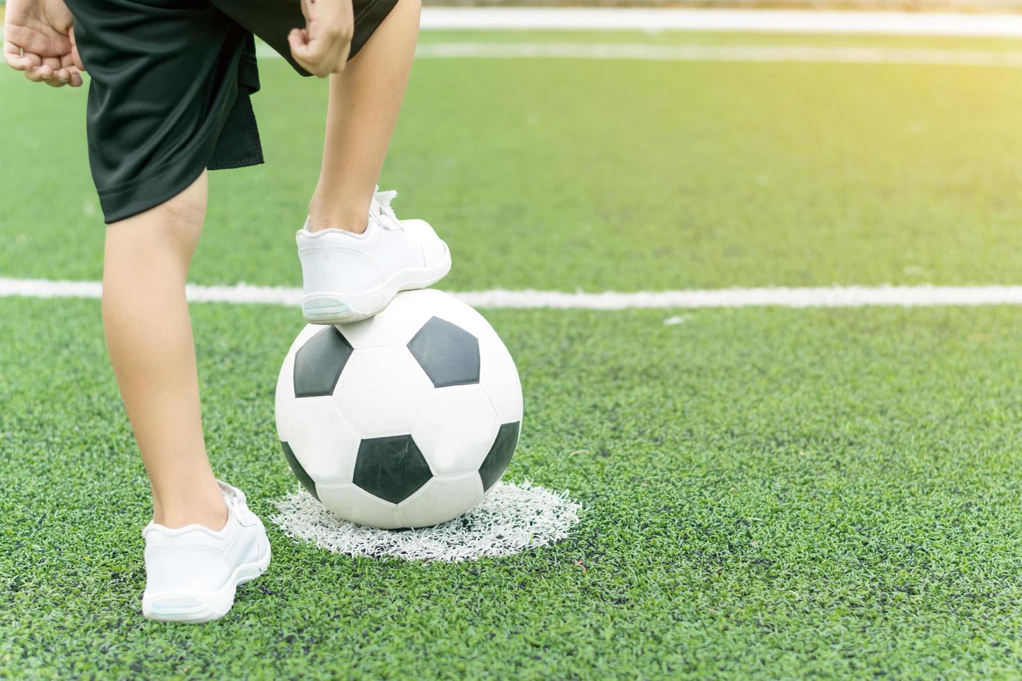 Perseo Persistente asignar Pies de un niño vestido con zapatillas blancas pisando una pelota de fútbol  1433104 Foto de stock en Vecteezy