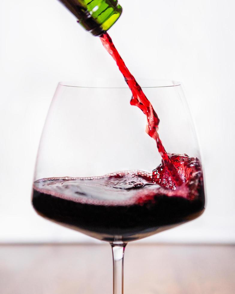 Red wine pouring into the glass photo