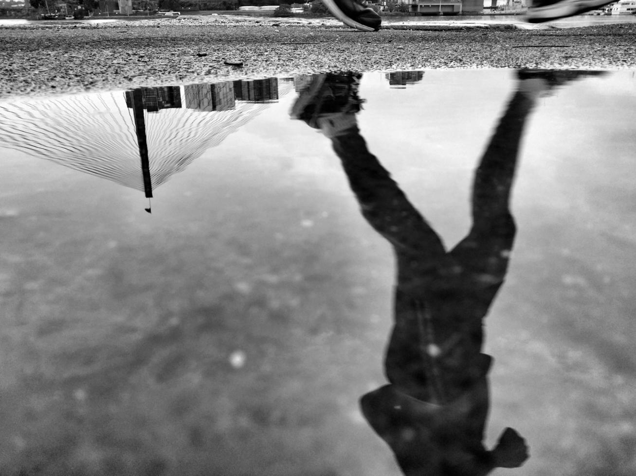 Puddle reflection of a man running photo