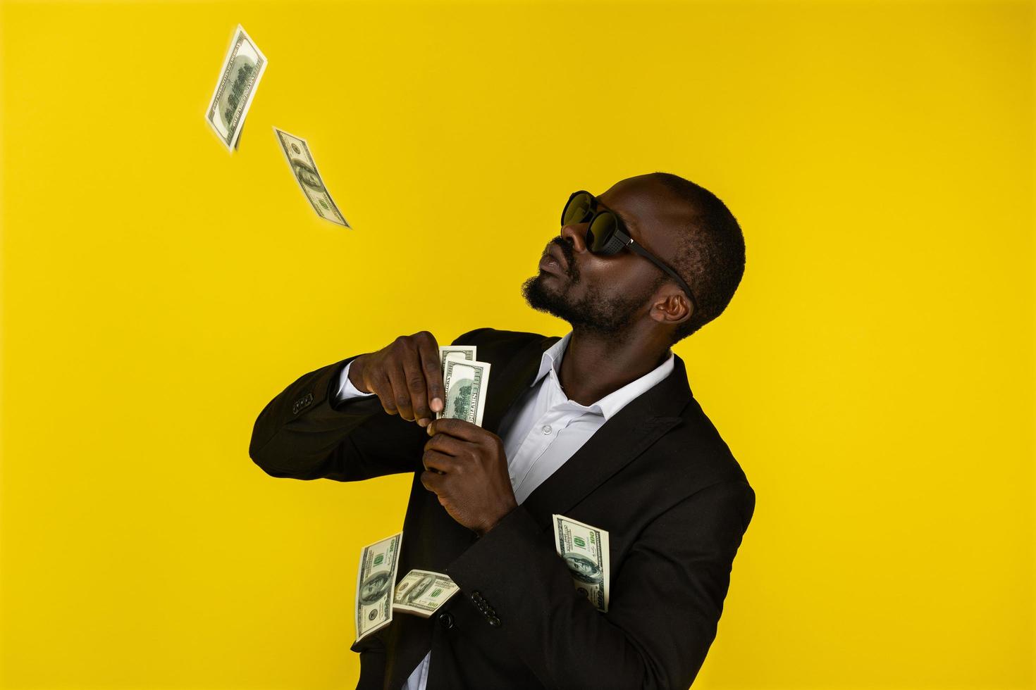 A cool black man throws up dollars photo