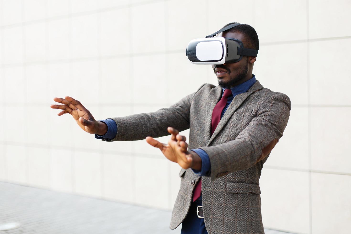 Hombre de negocios afroamericano juega en un vr-gafas de pie fuera foto