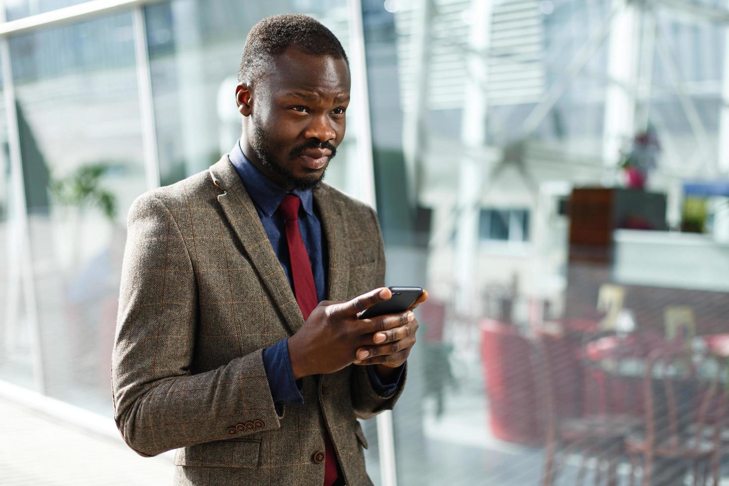 Elegante empresario afroamericano negro trabaja en su smartphone foto