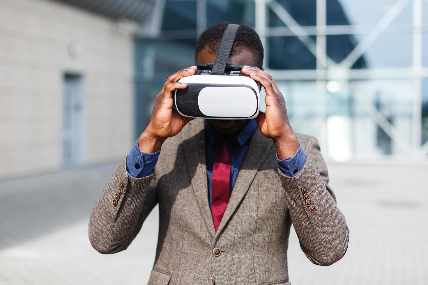 Hombre de negocios afroamericano juega en un vr-gafas de pie fuera foto