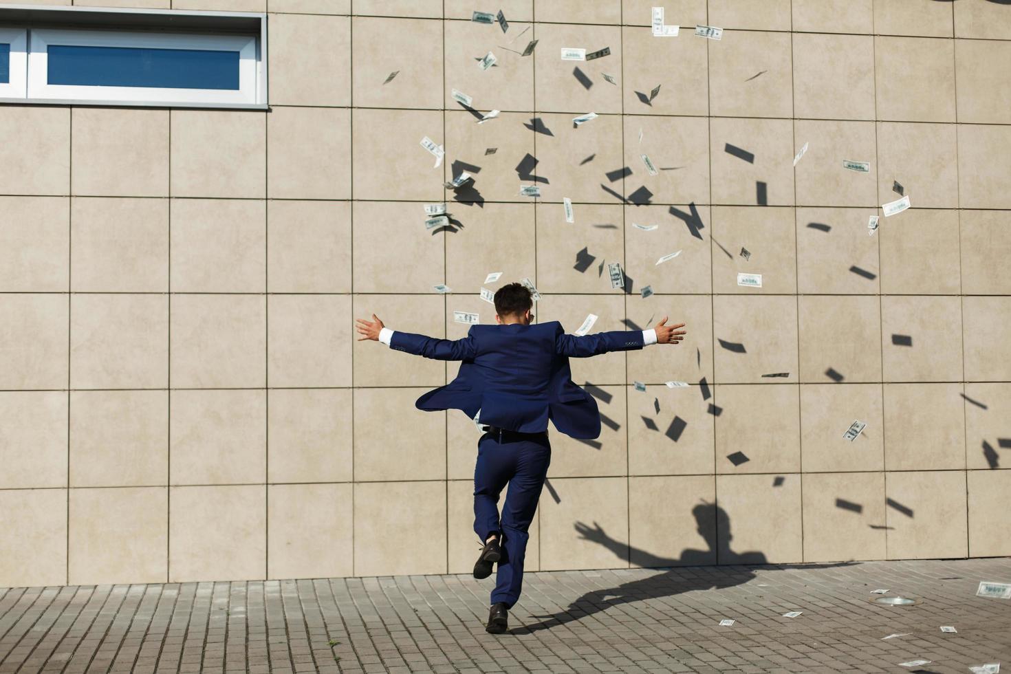 Young businessman throws around dollars photo