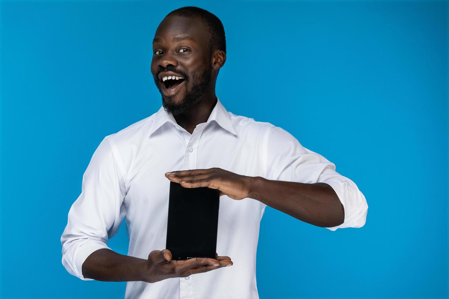 Cute man smiles and holds a tablet photo