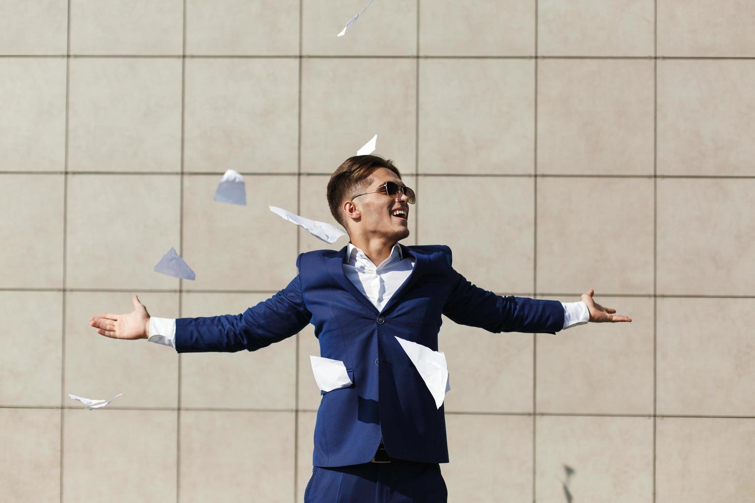 Young businessman throws away ripped papers photo