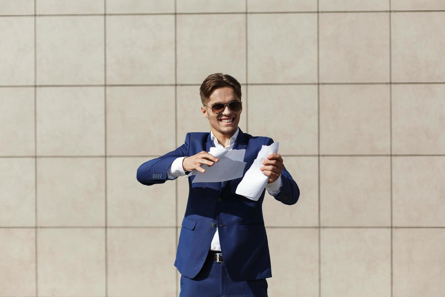 A young businessman tearing a piece of paper photo