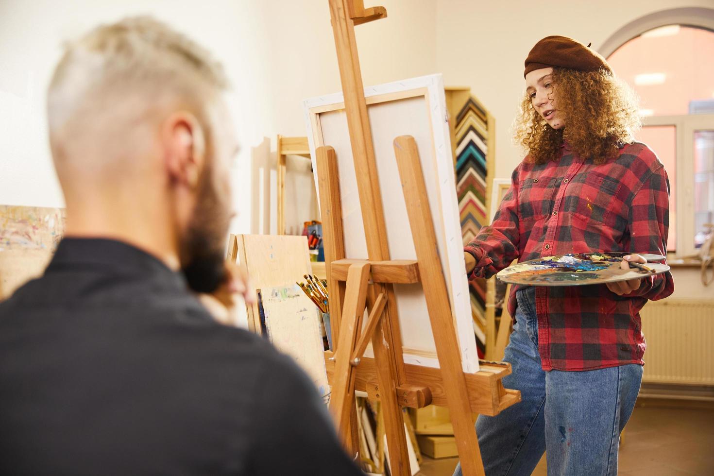 Curly girl is drawing a portrait of a man photo