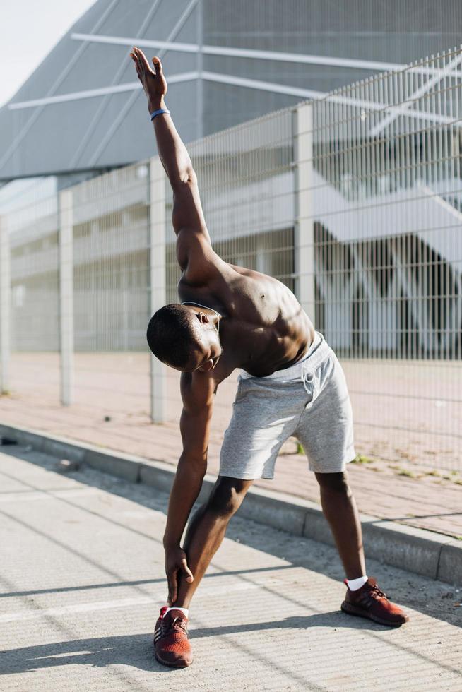 Handsome African American man does stretching before a work-out outside photo