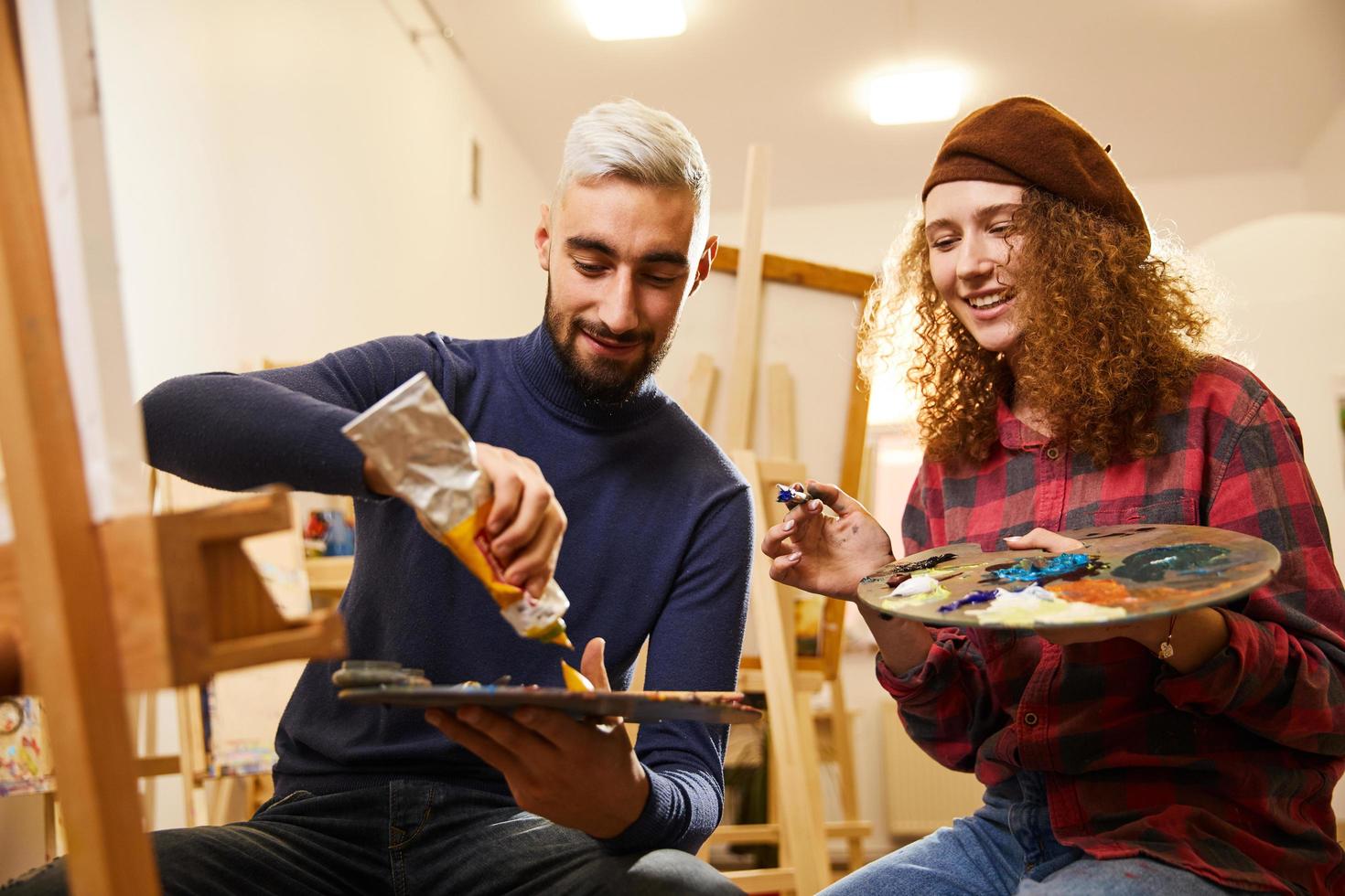 niña rizada y rubio pintando y sonriendo foto