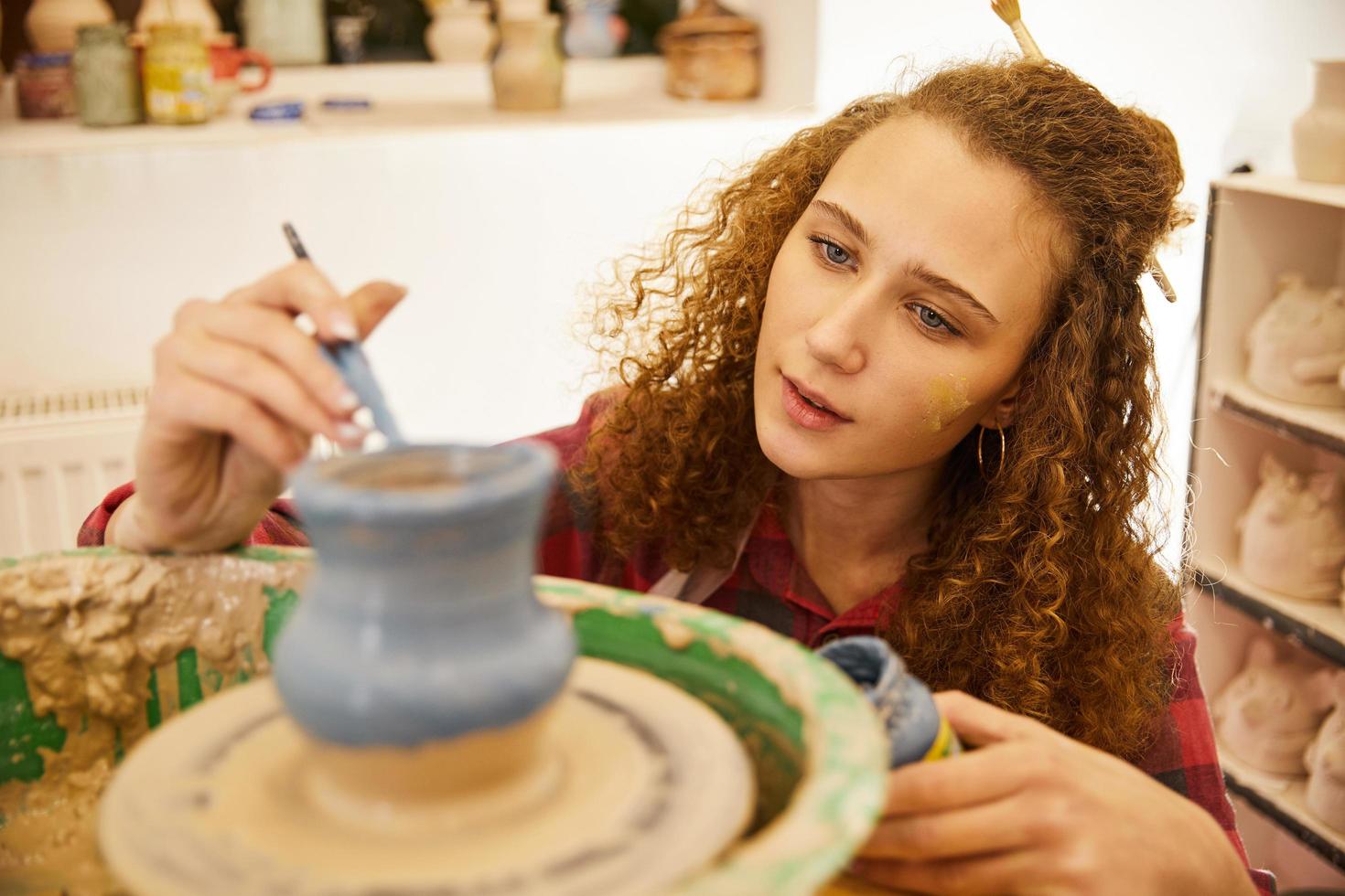 niña pintando cerámica foto