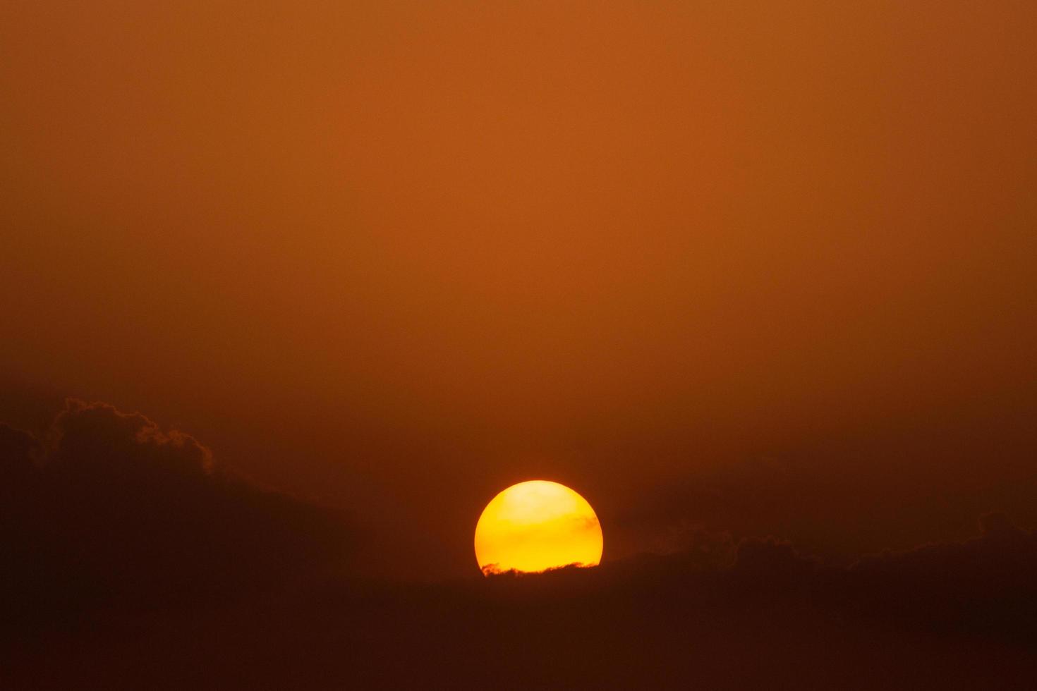 sol poniente detrás de las nubes foto