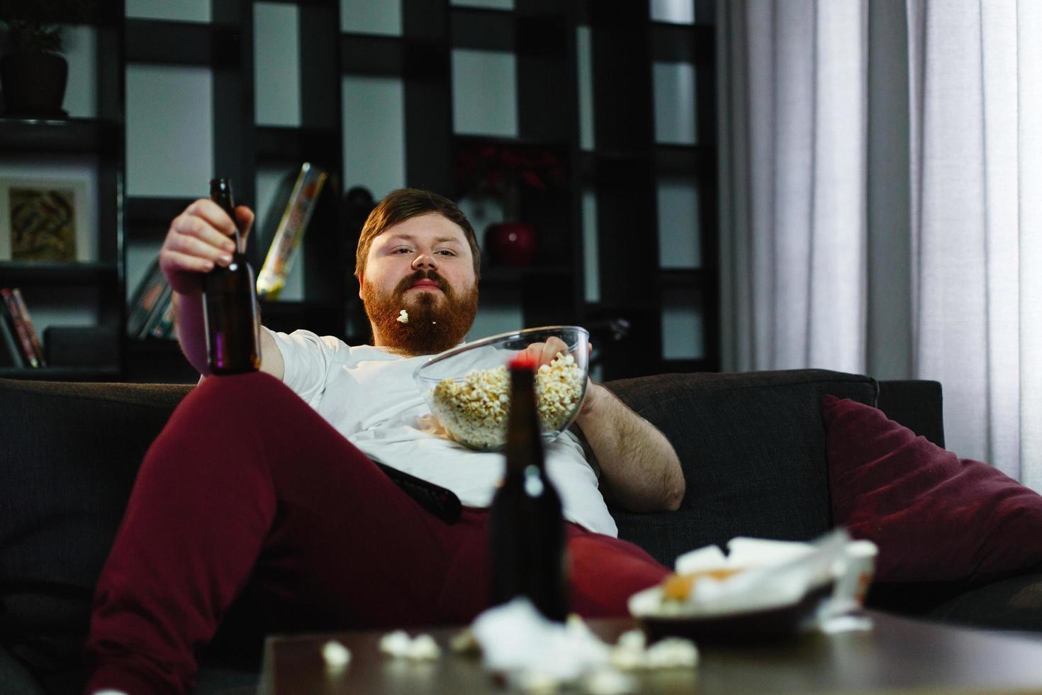 hombre relajante comiendo palomitas de maíz foto