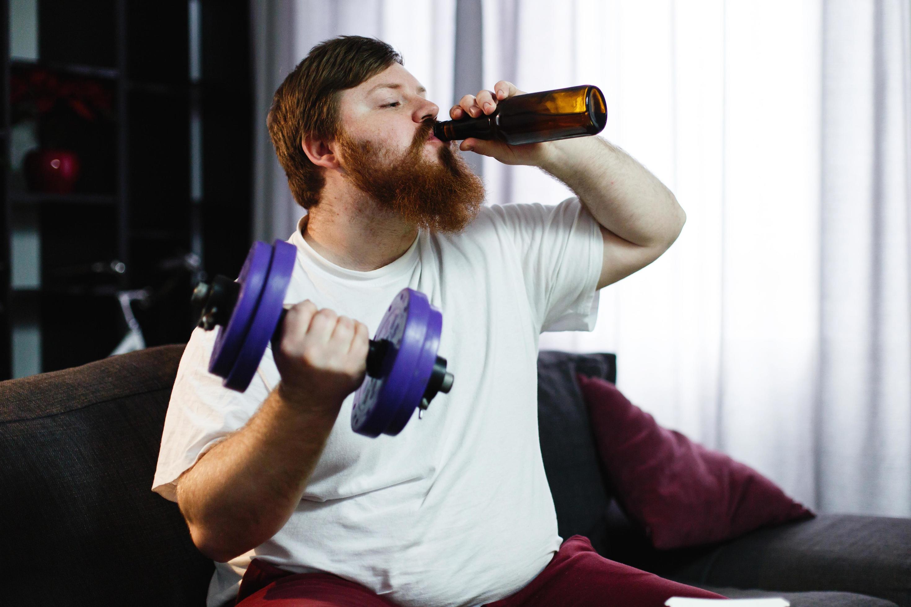 Man drinking a beer while lifting weights 1484789 Stock Photo at Vecteezy