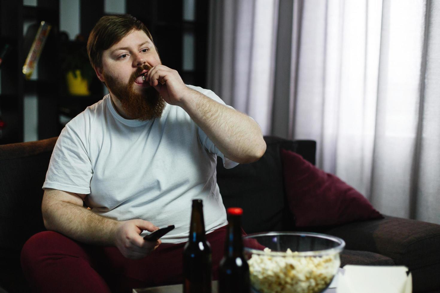 Happy fat man eats pop-corn photo