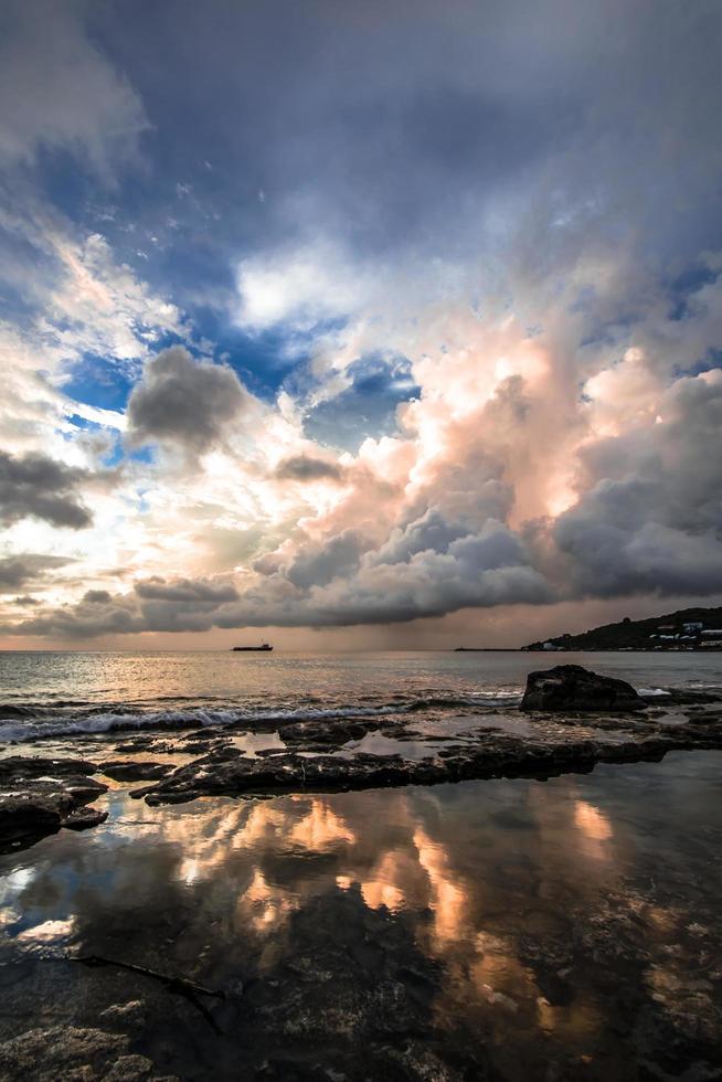 Cumulus clouds over the silhouette of a ferry on sea photo