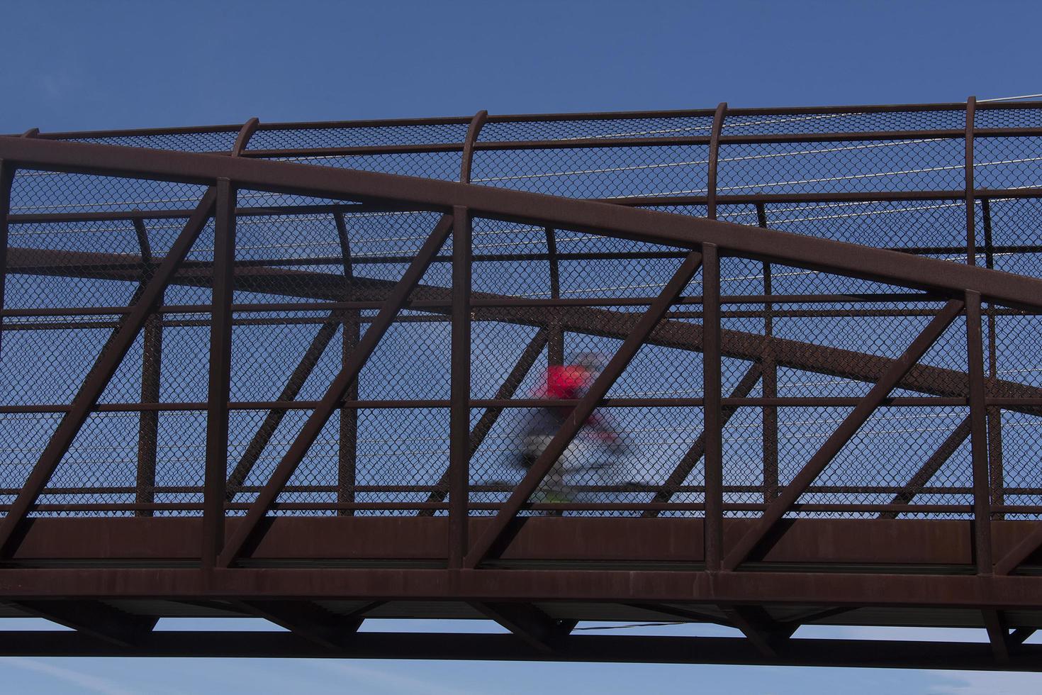 Cyclist in motion crossing bridge photo