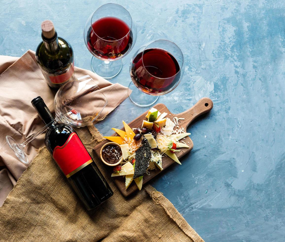 Wine bottle and glasses with mix of cheese photo