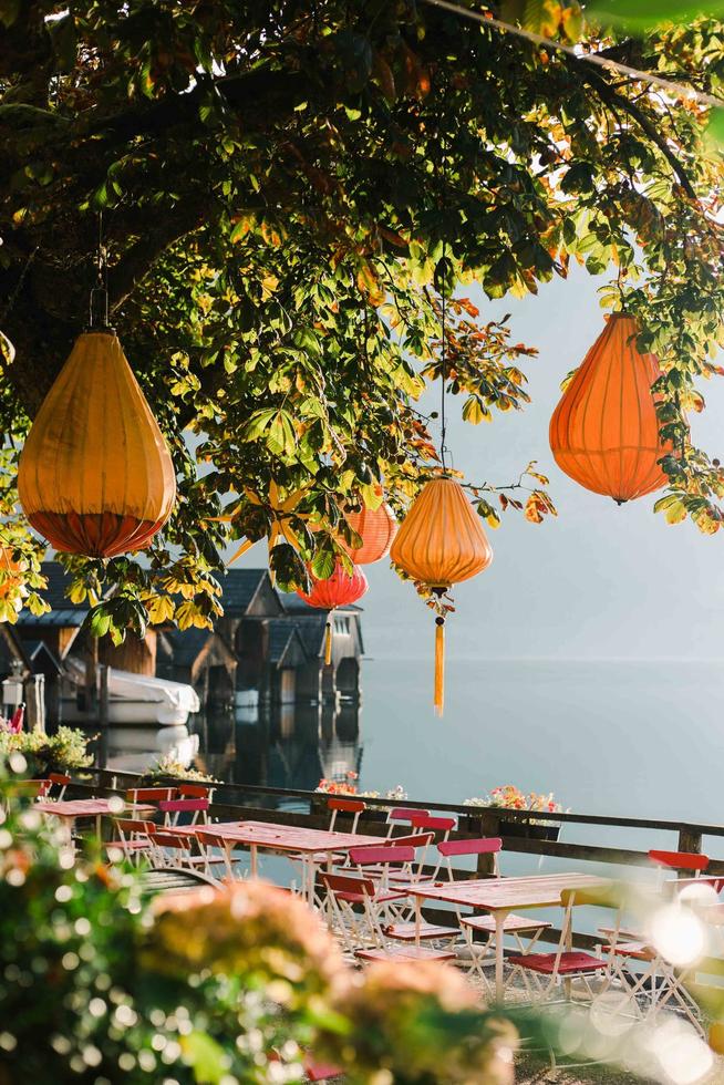 hallstatt, australia, 2020 - lámparas colgantes naranjas en un árbol en un café foto