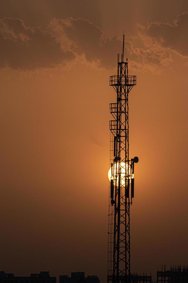 Silhouette of a radio tower with setting sun photo