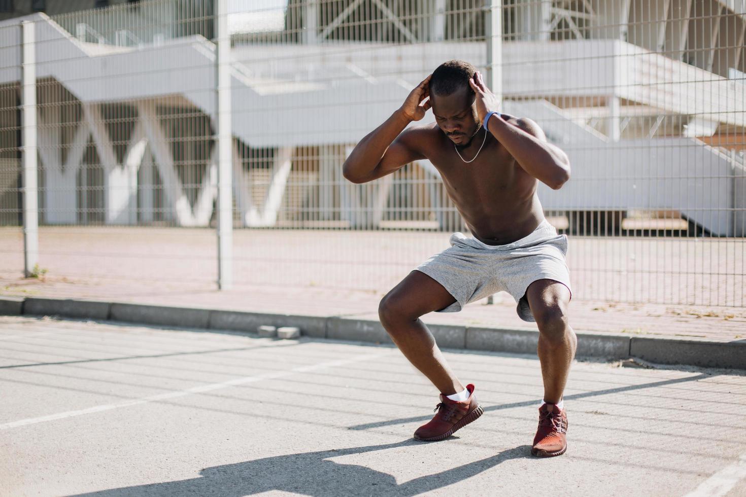 hombre afroamericano hace sentadillas foto