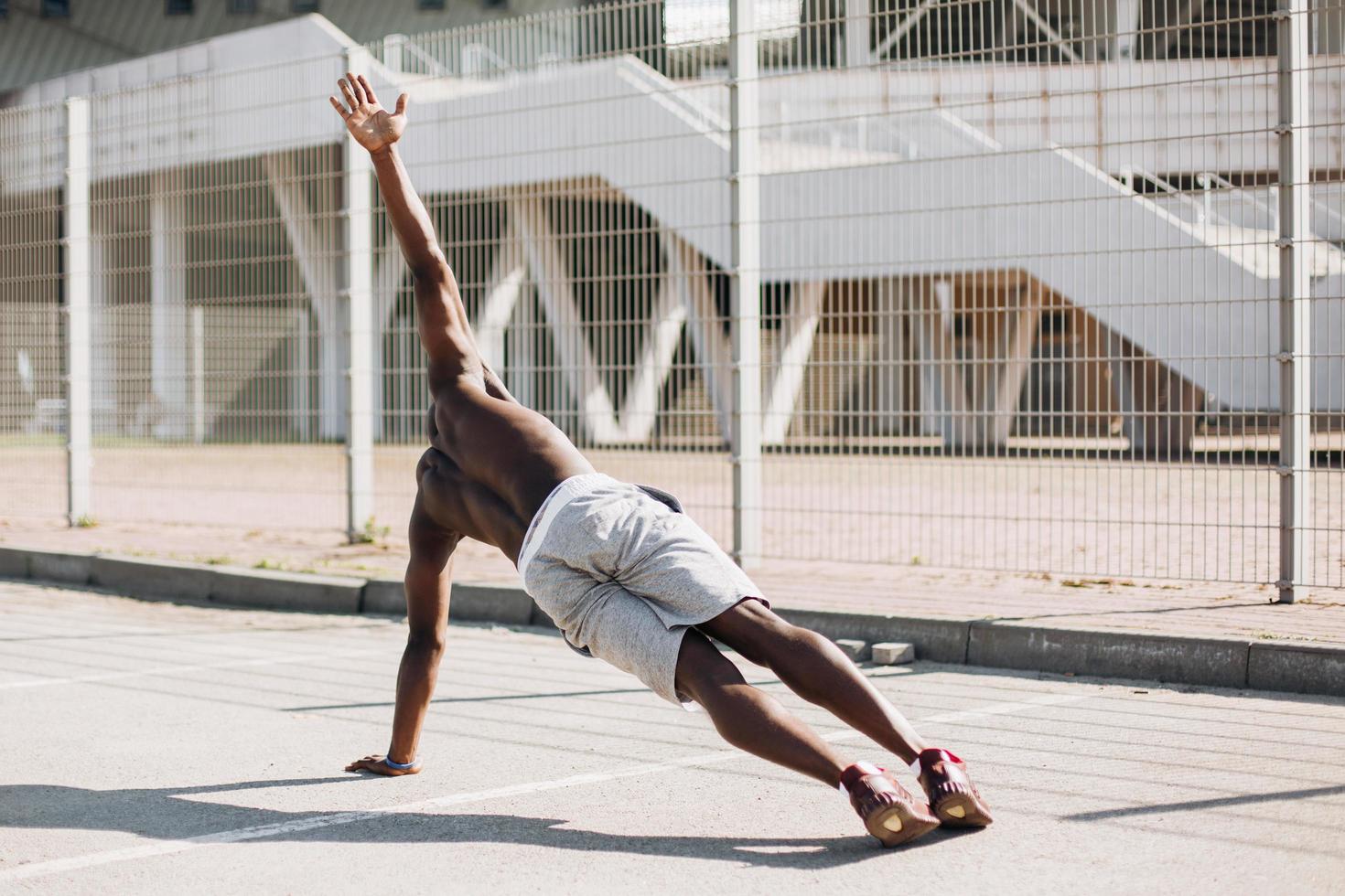 Hombre afroamericano haciendo plancha lateral foto