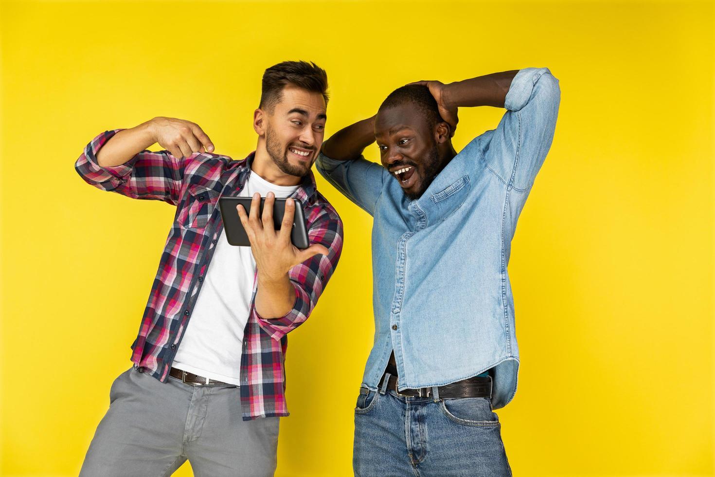 European and black man delighted of watching the tablet photo