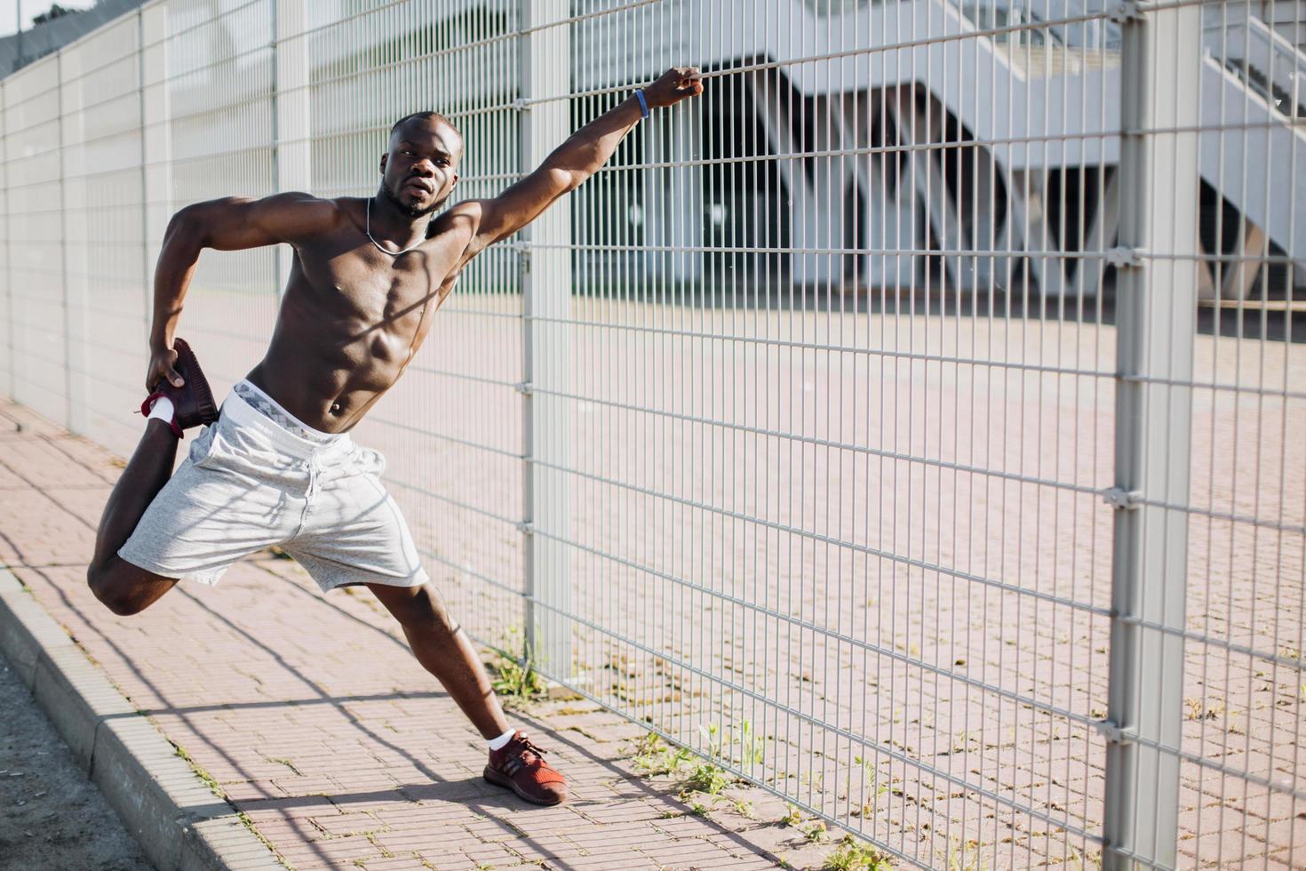 Black man stretching on a fence photo