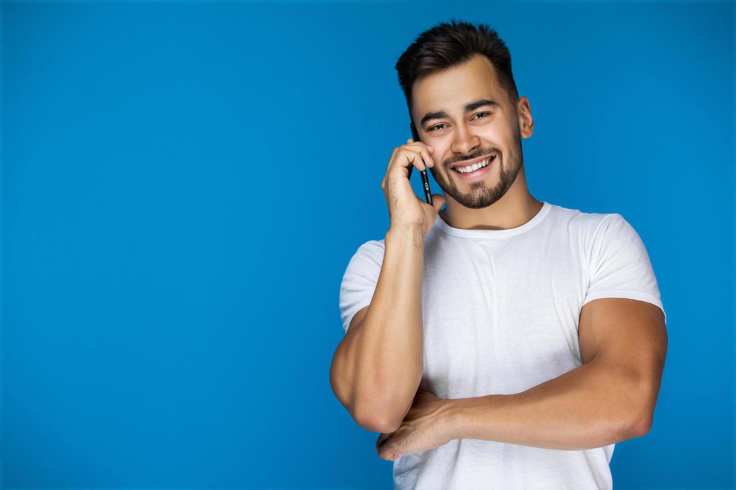 hombre sonriendo mientras habla por telefono foto