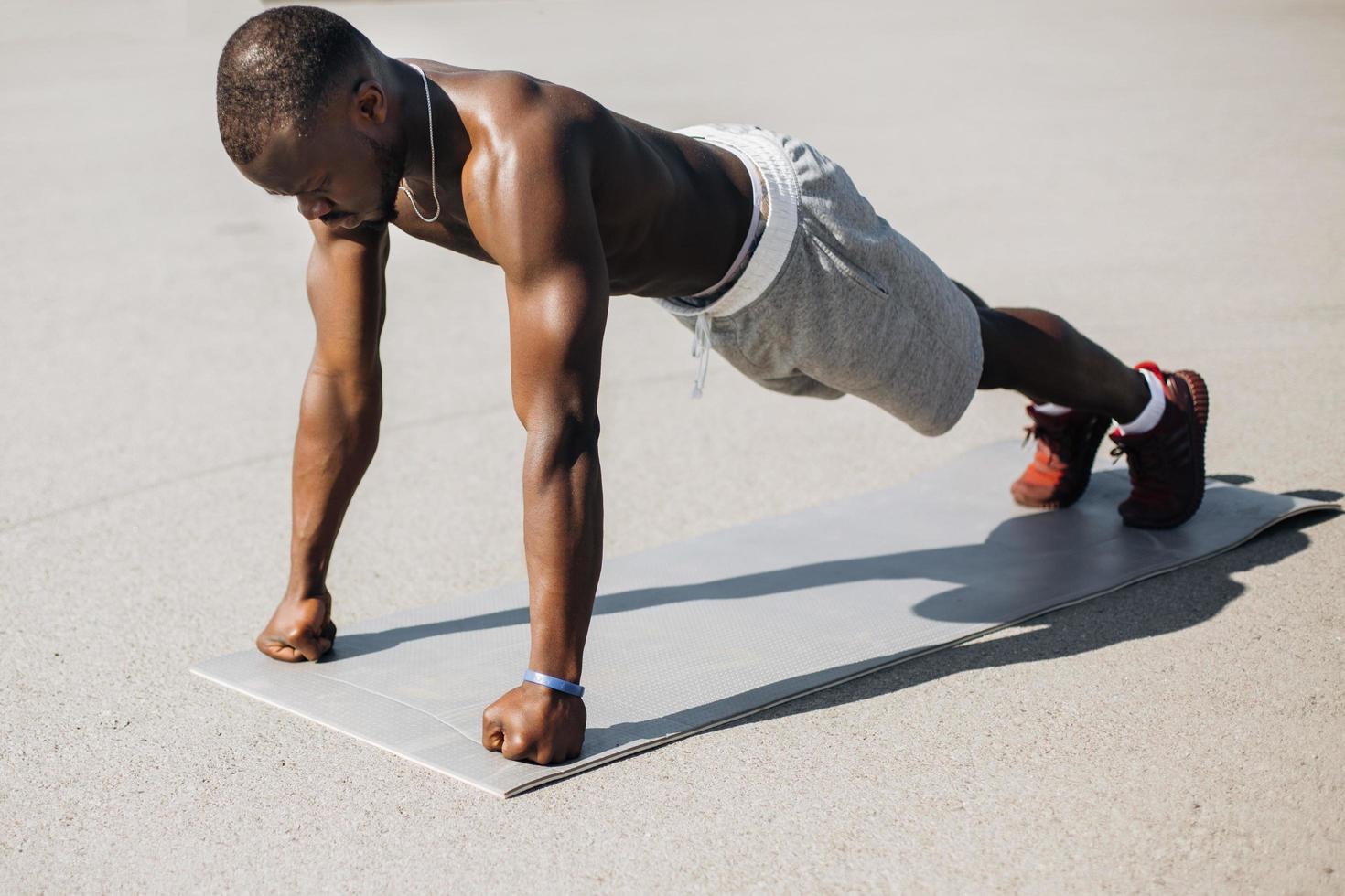 hombre afroamericano hace flexiones foto