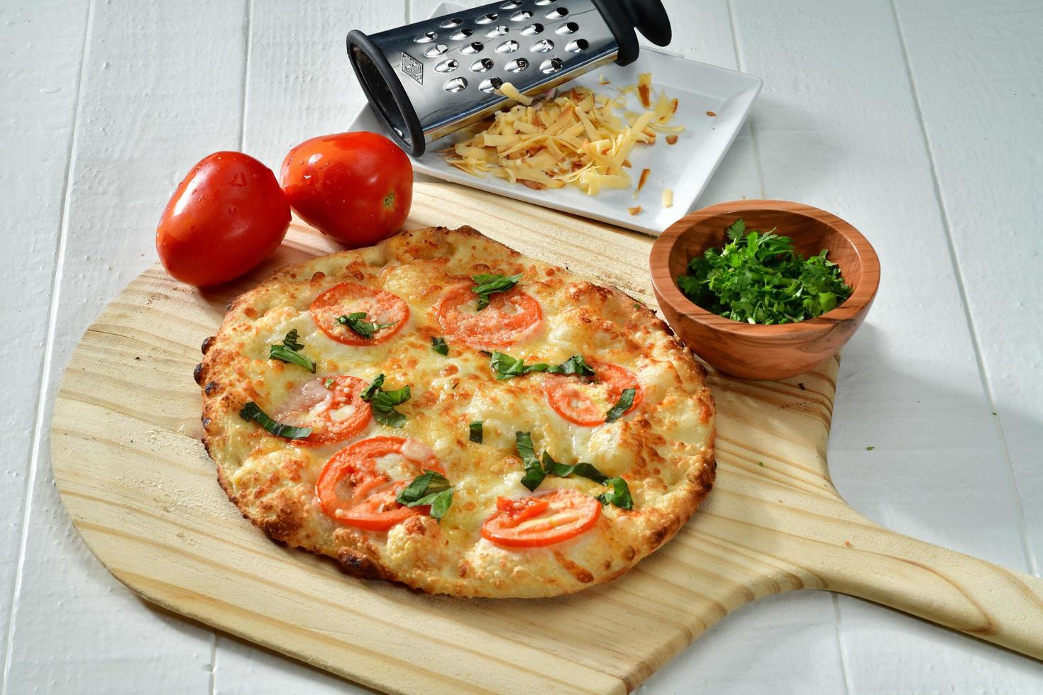 Cooked pizza on brown wooden pizza board photo