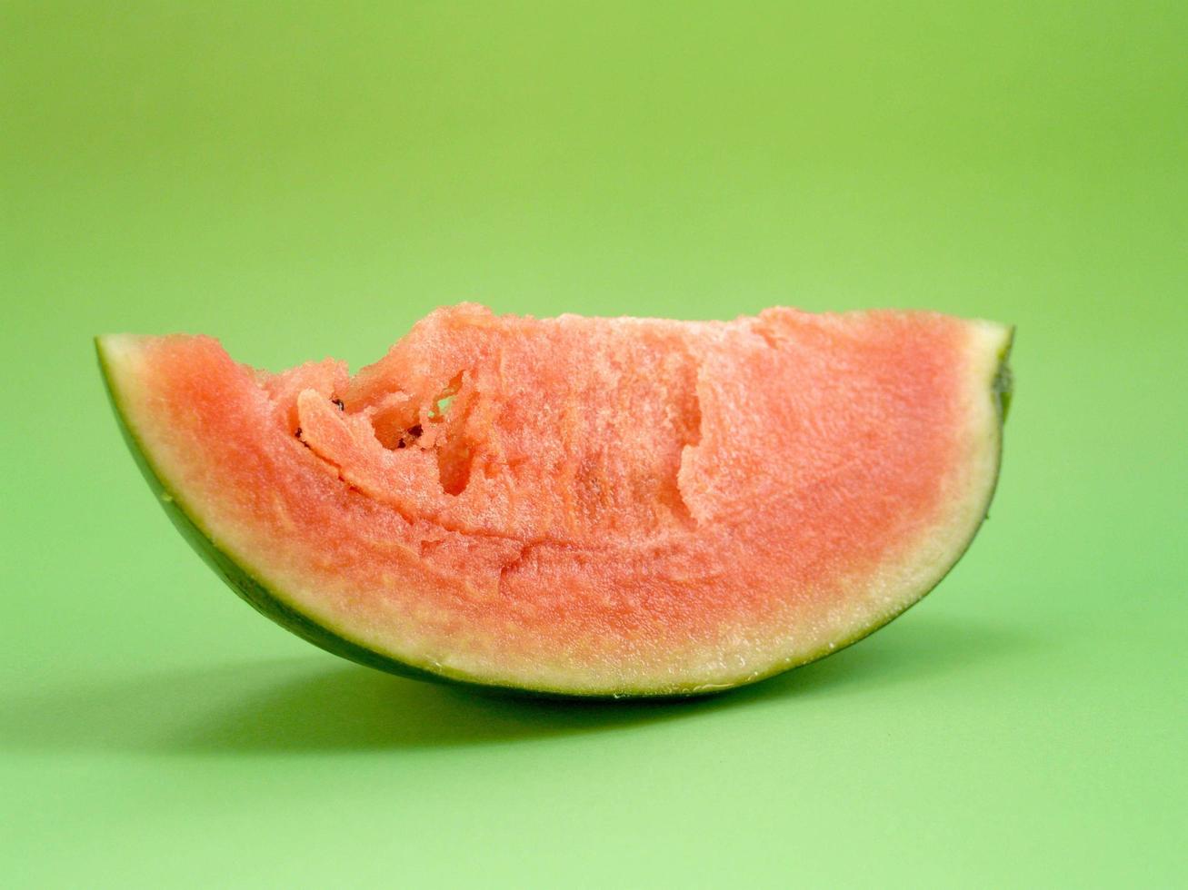 Watermelon slice on green background photo