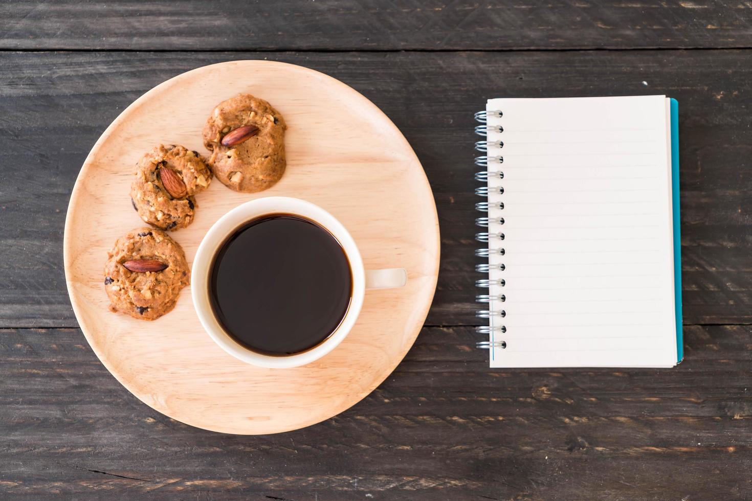 vista superior de café y galletas con un cuaderno foto
