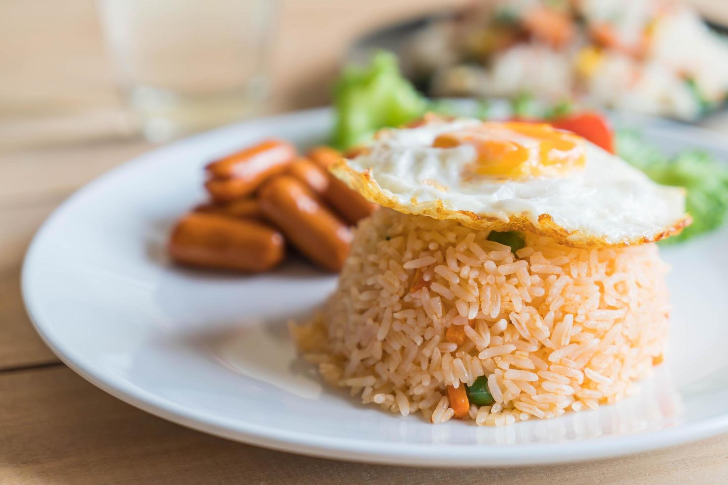 Plate with fried egg, rice, and sausage on it photo
