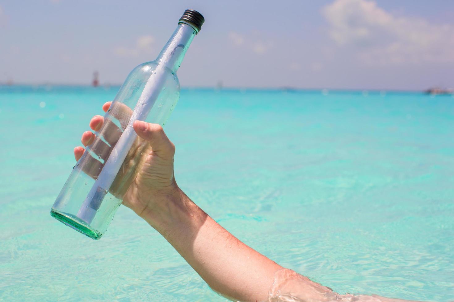 Person holding a glass bottle with a message in it photo