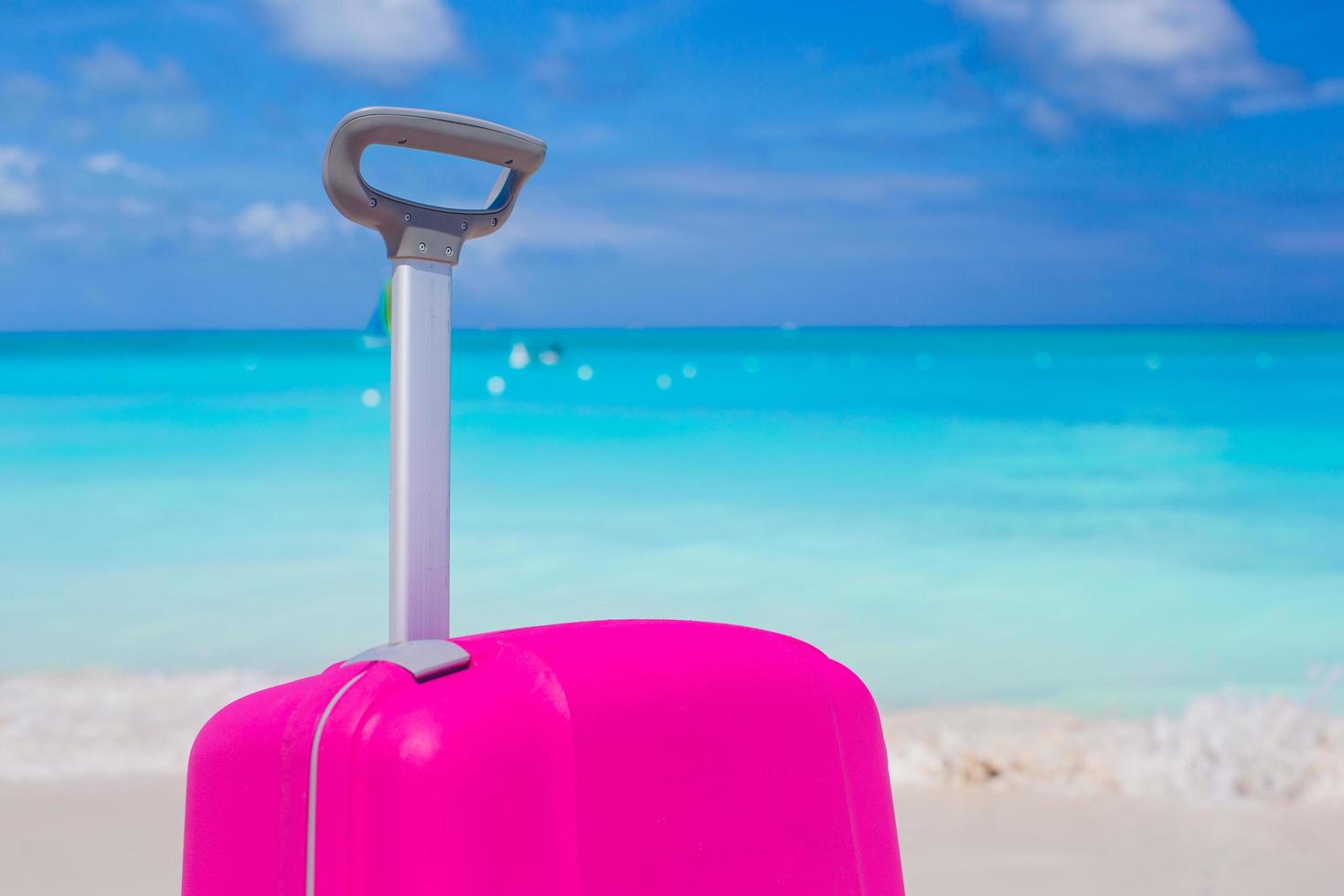 Pink suitcase on a beach photo